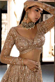 Champagne gold lehenga in sequin, crystal and glass beads. Teamed up with a very chic and smartly fitted choli accentuated with stylish cuts wi